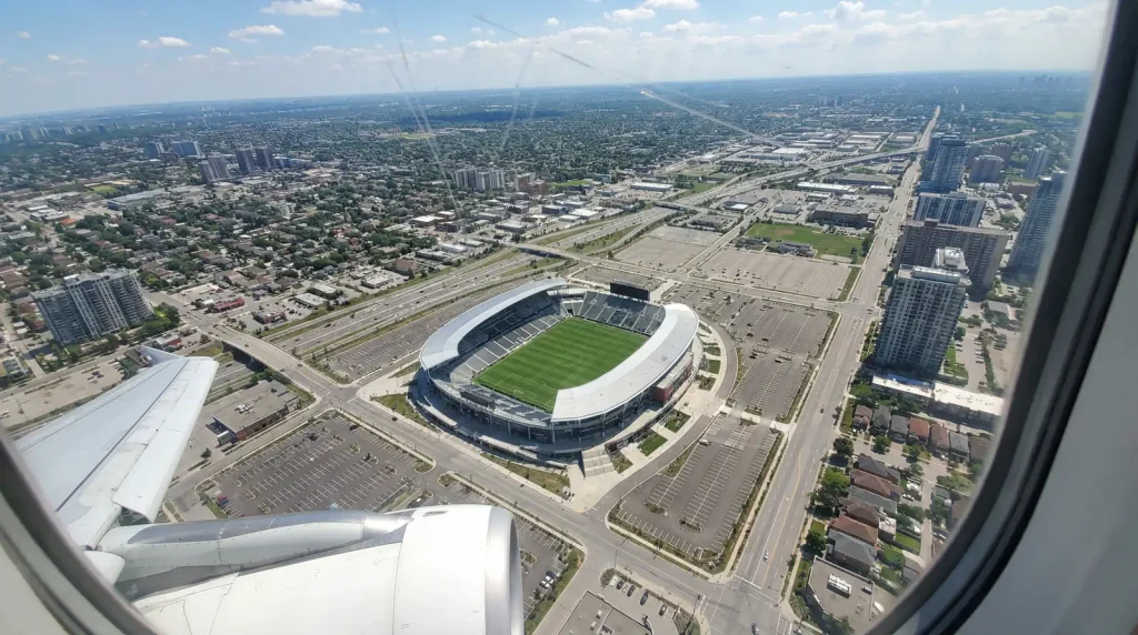 Vista aérea de un avión sobrevolando un estadio de fútbol de la MLS